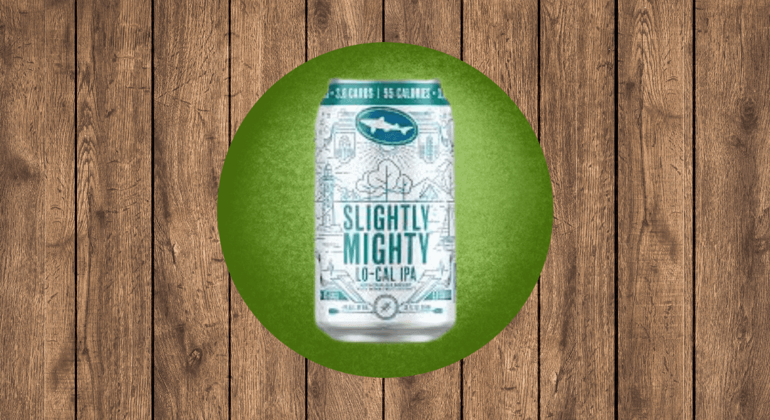 A can of Slightly Mighty Lo-Cal IPA on a green circular background, placed on a wooden plank surface.
